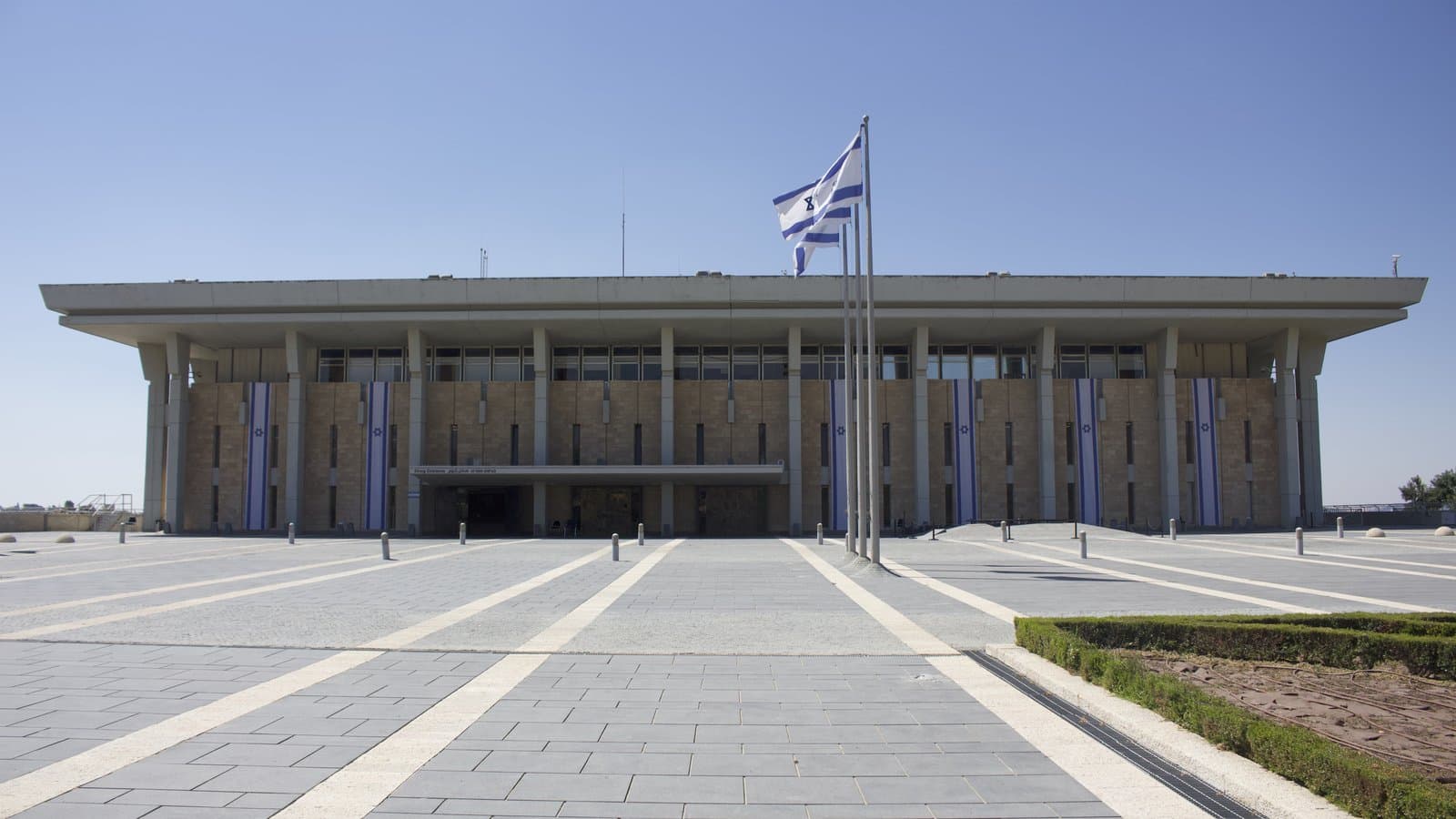 ARCHIVE PHOTO: The front of the Knesset building in Jerusalem with an Israeli flag.